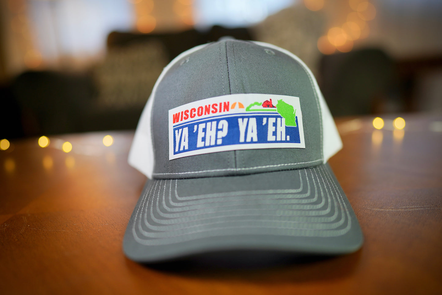"Ya 'Eh? Ya 'Eh." Wisconsin Plate Design Trucker Hat (White Mesh/ Charcoal Fabric)